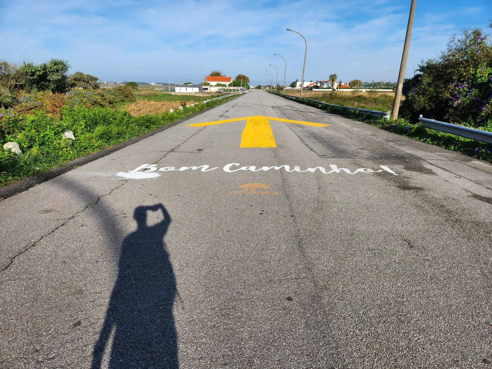 Bom Caminho felirat és hatalmas sárga nyíl az úton